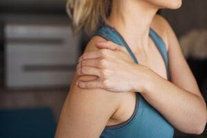 Female athlete rubbing her painful shoulder
