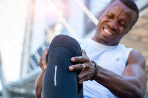 Male runner clutching his painful knee