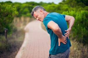 Athletic man rubbing his painful lower back