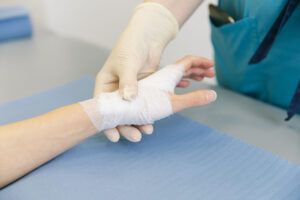 Close-up of medical provider holding patient's bandaged hand