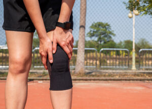 Female runner wearing a supportive black knee brace