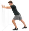 Man bracing his hands against a wall while performing stretching exercises for heel pain